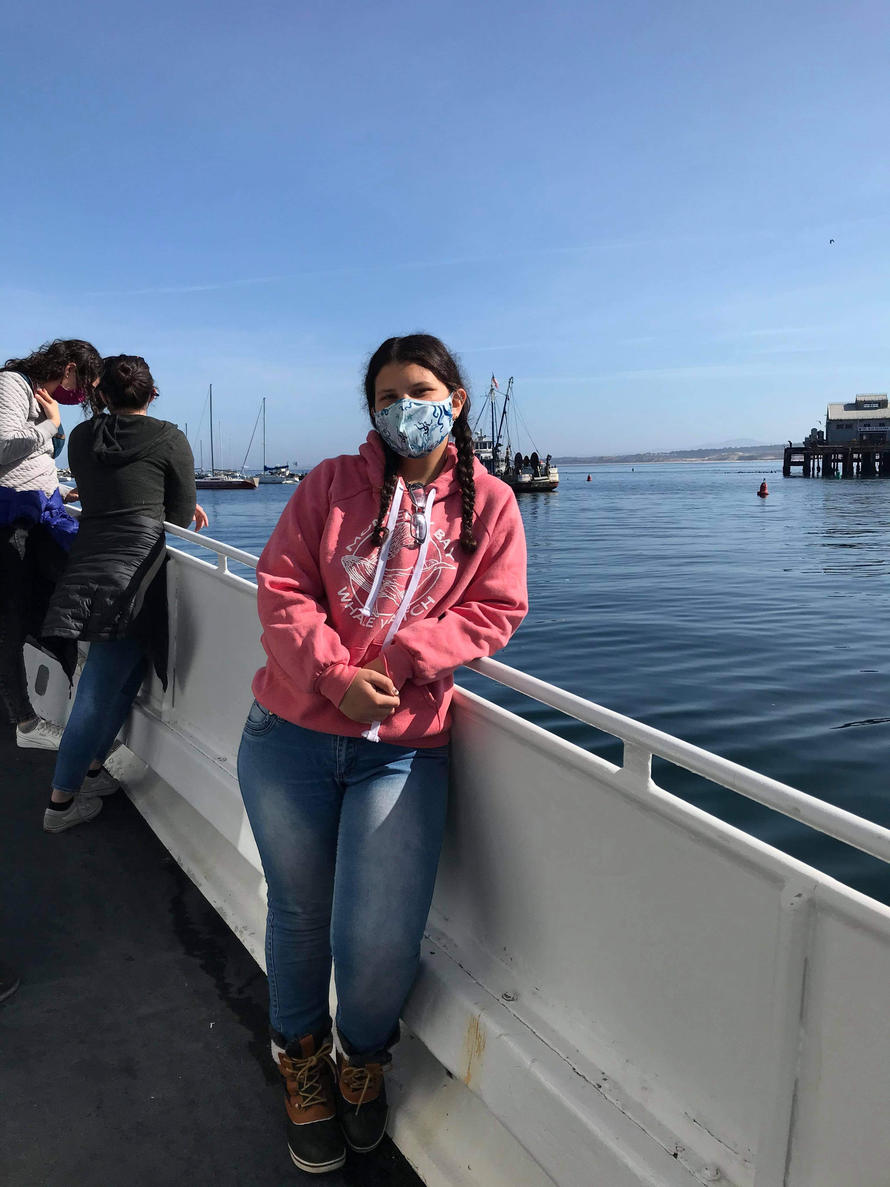 Student standing on a whale watching boat